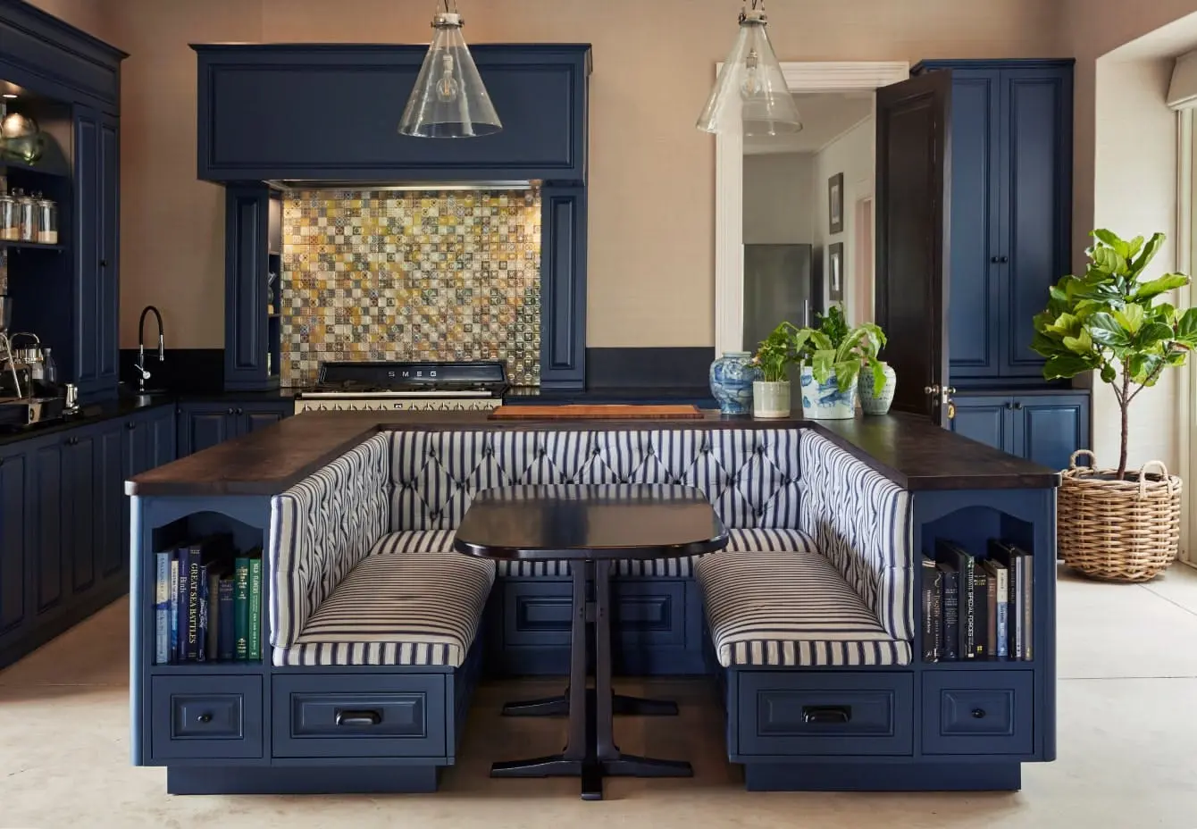 A kitchen banquette in a dark blue colour with a wooden top and black and white striped upholstery.