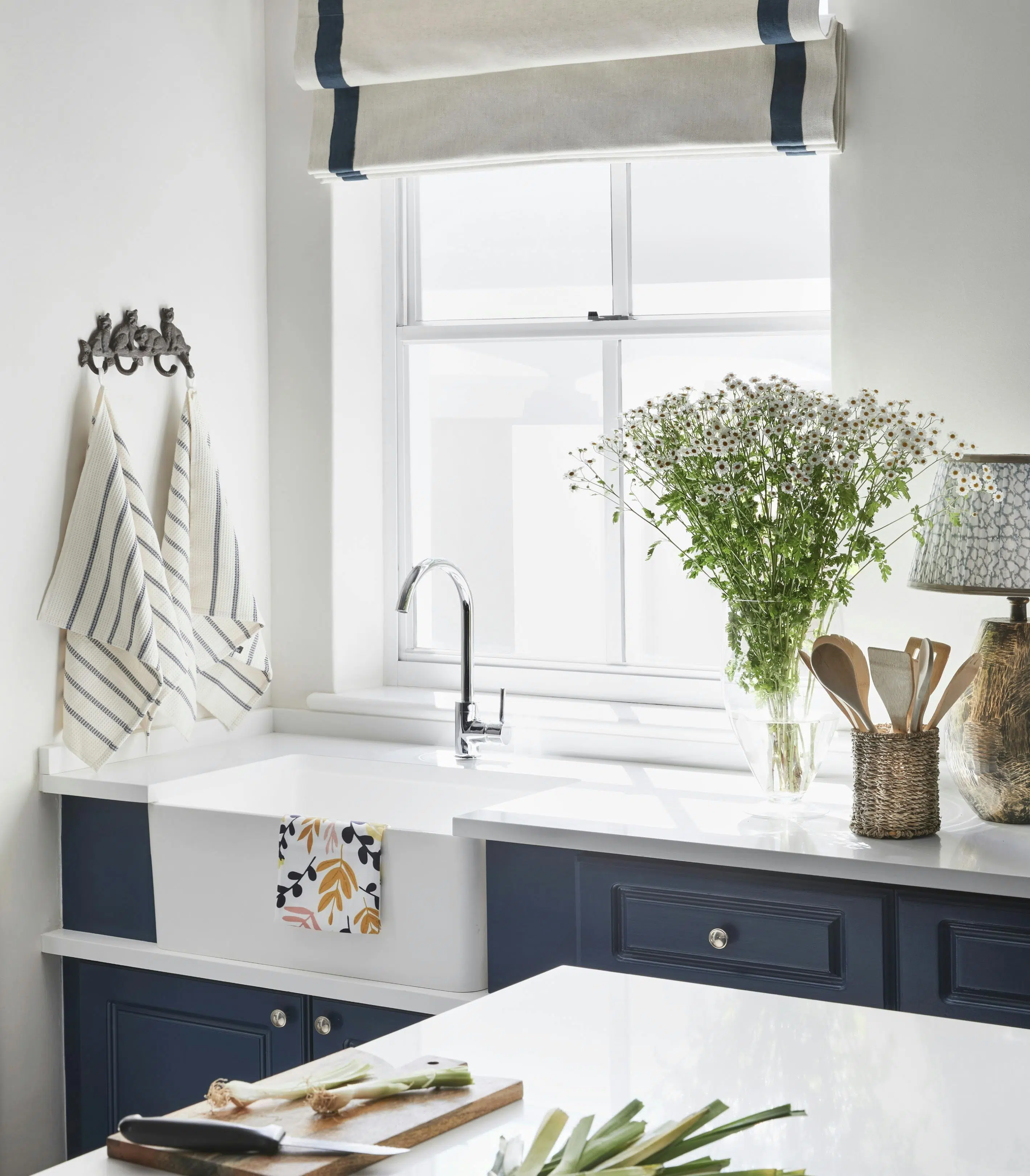 A kitchen with a window behind the faucet.